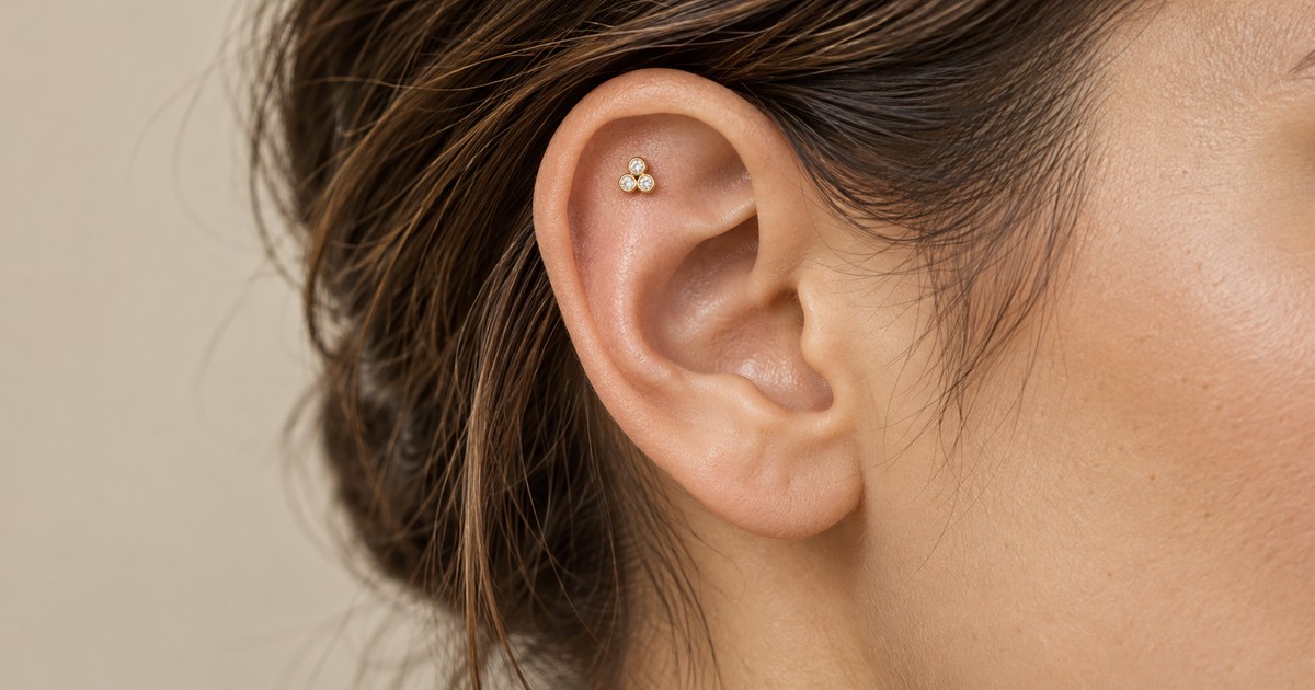Flat piercing με μικρό χρυσό διακοσμητικό στον επίπεδο επάνω χόνδρο του αυτιού