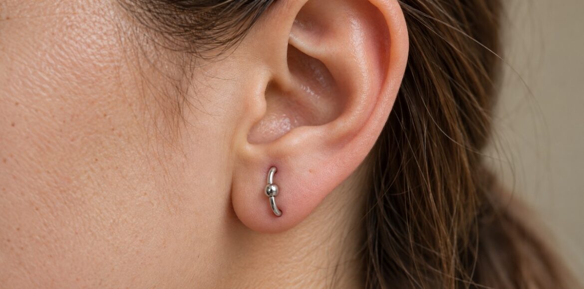 Ενδεικτικό orbital piercing στον λοβό με έναν ασημί κρίκο που συνδέει δύο διατρήσεις