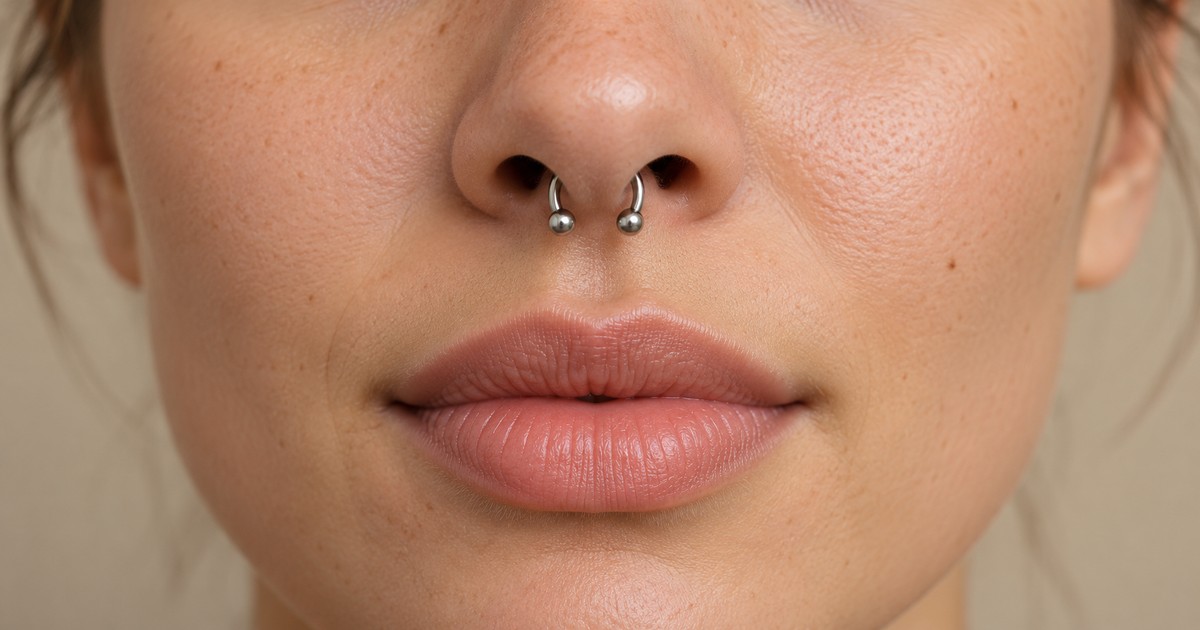 Septum piercing με μικρό ασημί πέταλο στο κέντρο κάτω από τη μύτη